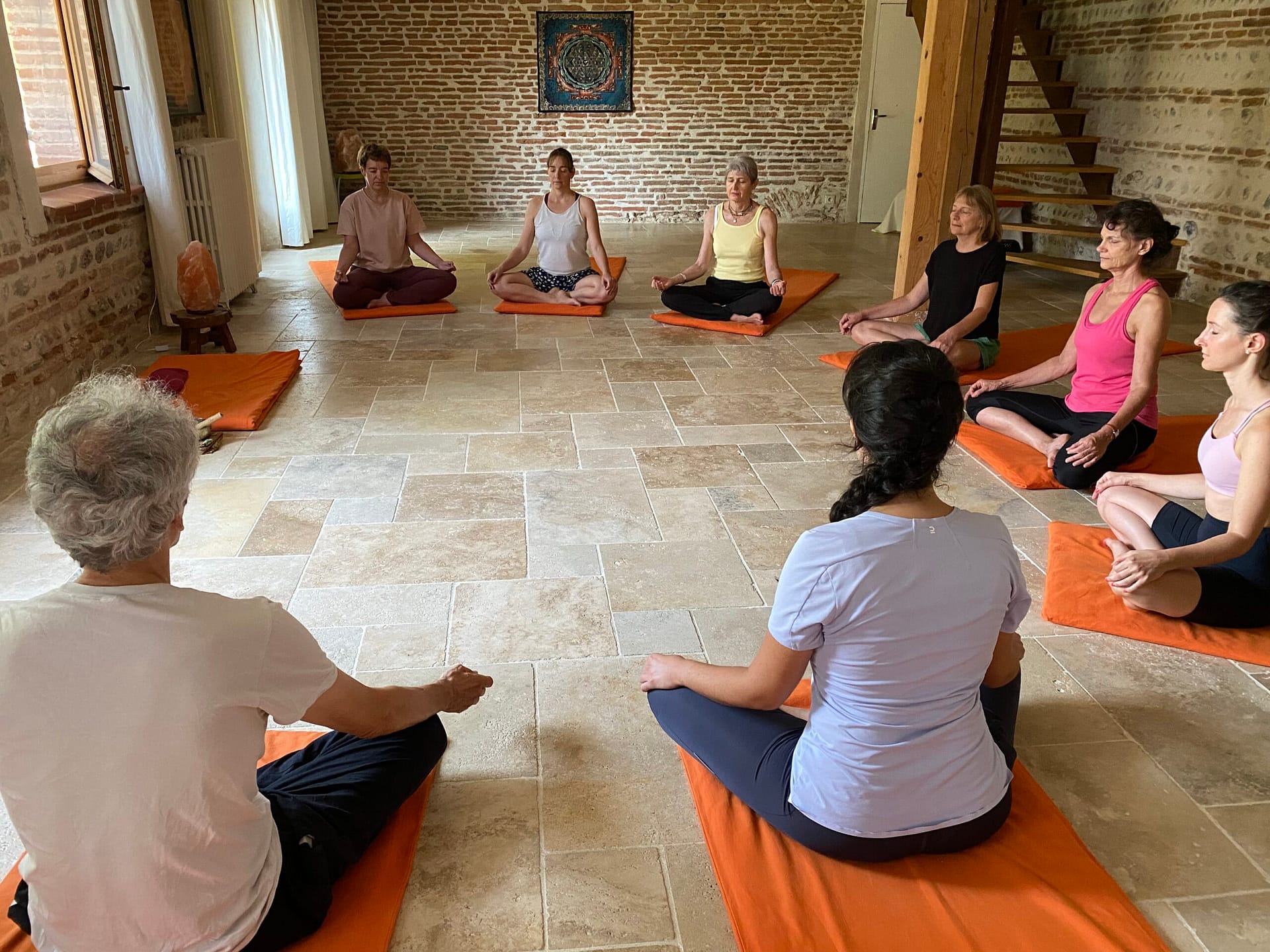 Personnes en méditation dans une salle de yoga à Venerque